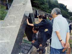 写真　顕彰碑に見入る木島日出夫さんと廻本多都子諏訪市議